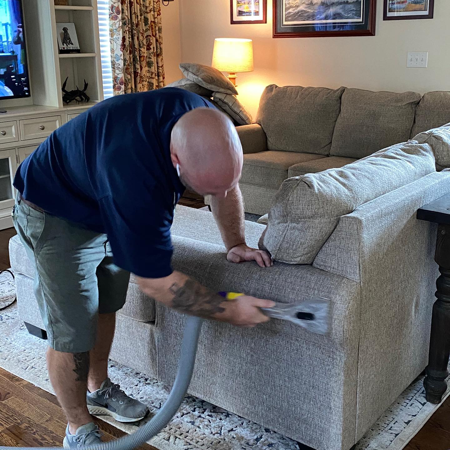 A Clean Floors team member cleaning a fabric sofa