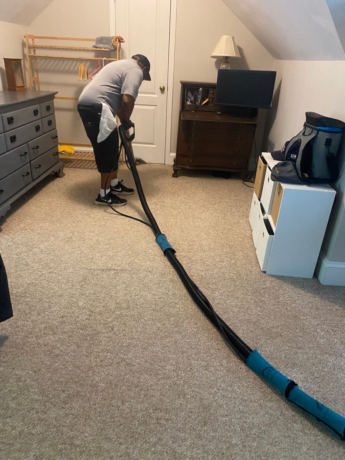 A Clean Floors team member cleaning a bedroom carpet